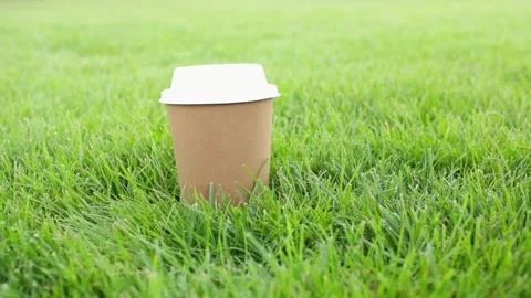 Biodegradable disposable cup of coffee on green grass. Stock Footage 154305039