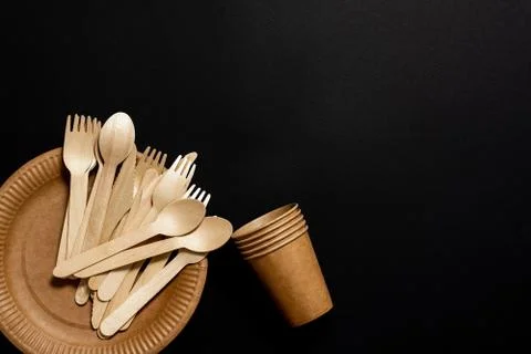 Biodegradable disposable tableware on a black background. Stock Photos