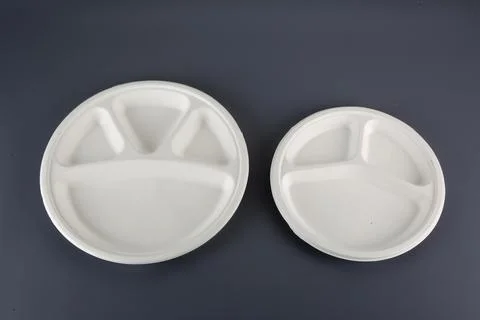 Biodegradable disposable tableware plates, glasses and spoons with forks on.. Stock Photos