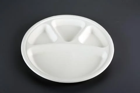 Biodegradable disposable tableware plates, glasses and spoons with forks on.. Stock Photos