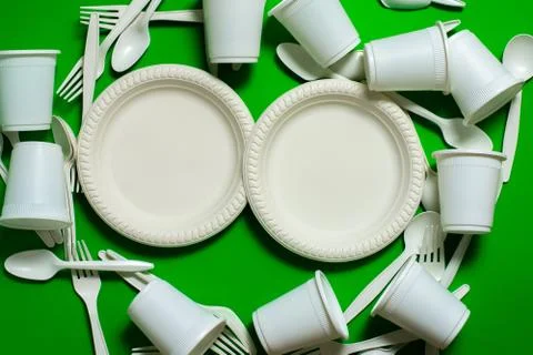 Biodegradable eco-friendly disposable tableware on a green background. Stock Photos