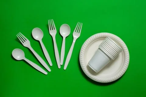 Biodegradable eco-friendly disposable tableware on a green background. Stock Photos