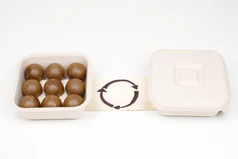 Biodegradable paper pulp packaging container with seed balls and recycle symb Stock Photos