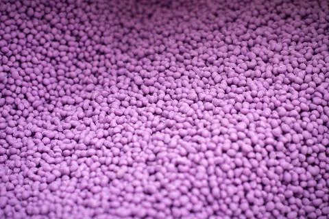 Biodegradable plastic granules texture, plastic polymer pellets color purple Stock Photos