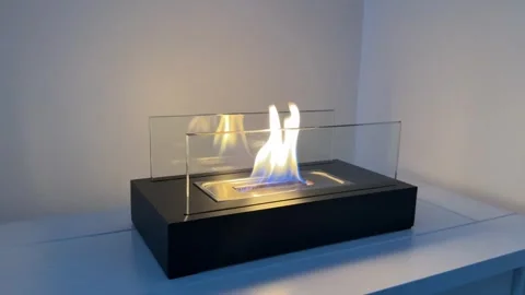 Bioethanol tabletop fireplace burning on a white surface close up 4K Stock Footage 345754587