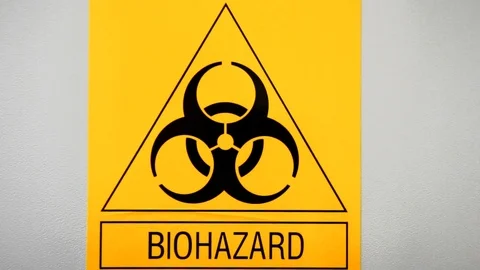 Biohazard symbol, yellow triangle-shaped sign on laboratory wall Stockbeeldmateriaal 124555928