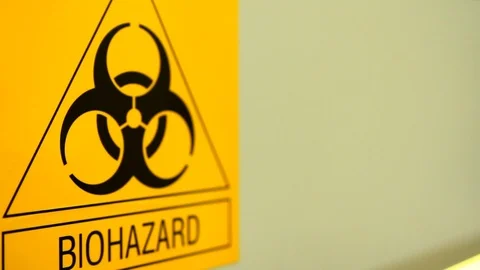 Biohazard symbol, yellow triangle-shaped sign on laboratory wall Vídeo Stock 124555941