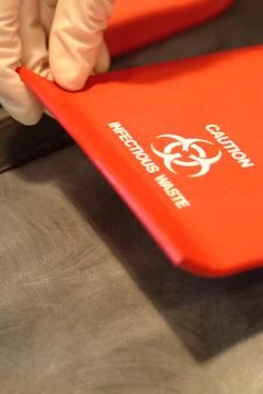 Biohazard warning on concealed sharps container Foto stock