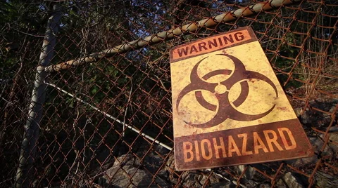 Biohazard Warning | sunset rusted fence | tilt up Stock Footage