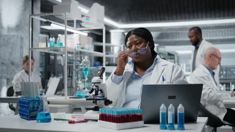 Bioinformatics scientist doing brainstorming while working on laptop in lab Stock Footage 326368435