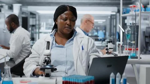 Bioinformatics scientist doing brainstorming while working on laptop in lab Stock Photos