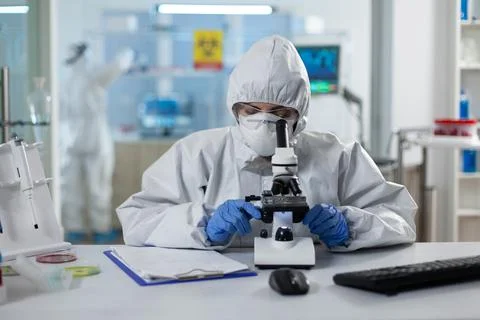 Biologist researcher wearing ppe medical suit analyzing genetics sample Stock Photos