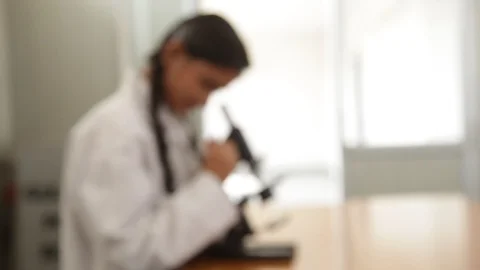 A biology student is performing science experiments with a microscope. Stock-Footage 114479697