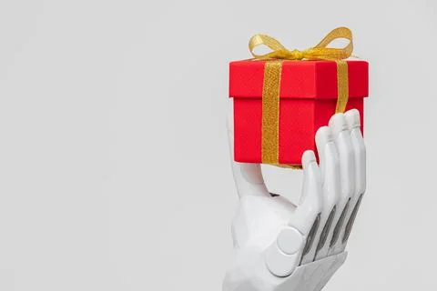 A bionic prosthetic arm or forearm in white on a beige background holds a red Stock Photos