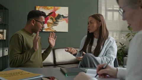 Biracial Couple Arguing while Therapist Taking Notes during Family Psychotherapy Stock Footage 312467387