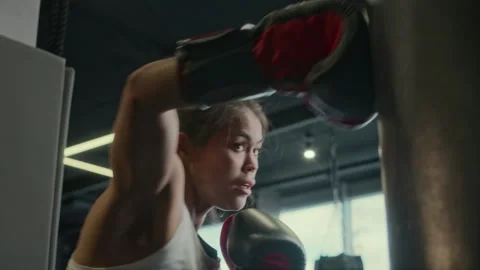 Biracial Female Boxer Performing Ferocious Routine on Punch Bag at Gym Stock Footage 277559699
