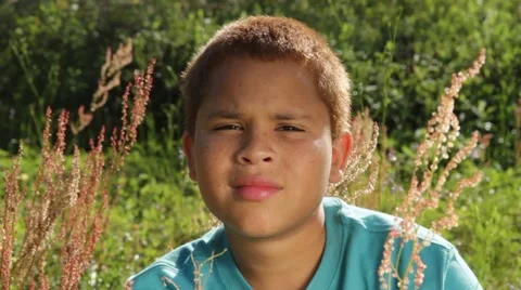 Biracial kid looks at camera with different expressions in a field Stock Footage 45522895
