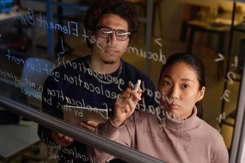 Biracial Programmers At Work In Evening Foto stock