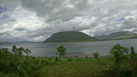 Birch grove and centered rounded mountain over fjord in Andoya Norway 库存影片 343379922