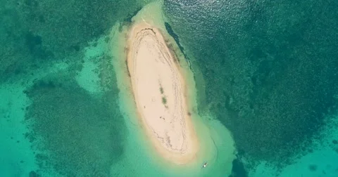 Bird eye aerial shot of a tiny island surrounded by beautiful turquoise water Stock Footage 61550001
