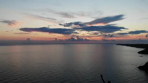 Bird eye flight evening sun sets and colours clouds over sea Video stock 103182638