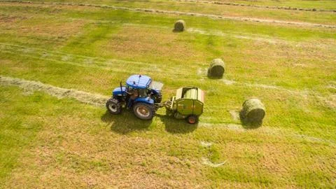 Bird eye of Man at work on the tractor with hay baler Stock Photos