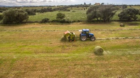 Bird eye of Man at work on the tractor with hay baler Stock Photos