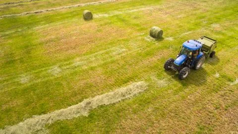 Bird eye of Man at work on the tractor with hay baler Stock Photos