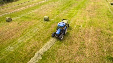 Bird eye of Man at work on the tractor with hay baler Stock Photos