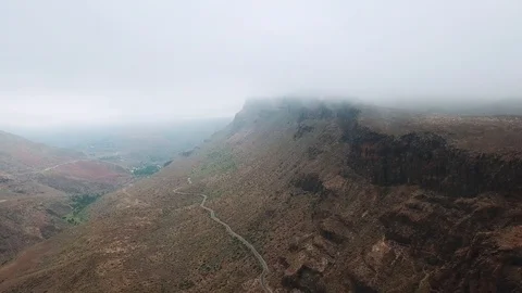 Bird eye view of a mountain cliff in overcast. The fog descends to the mountains Stock Footage 94114596