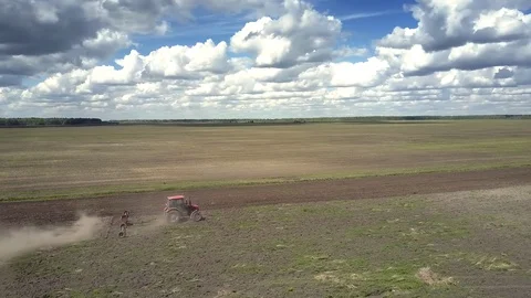 Bird eye view old tractor plows large empty field in dust Stock Footage 103409421