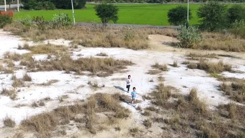 Bird eye view from remote control flying drone of two asian boy running  Stock Footage 71900972