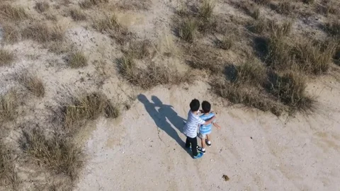 Bird eye view from remote control flying drone of two asian boy play together on Stock Footage 71900986