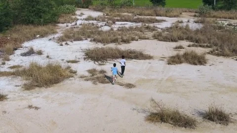 Bird eye view from remote control flying drone of two asian boy running  Stock Footage 71900996