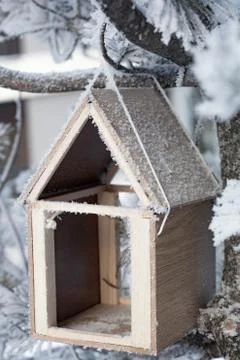 Bird feedbox hanging on the tree in the snow and frost.. Stock Photos