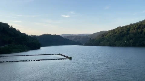 Bird Flying Over Titab Dam Reservoir with Floating Fish Cages in Bali Stock Footage 335509489