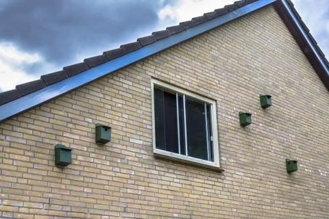 Bird house nesting boxes for house sparrow on a building in urban environment Stock Photos