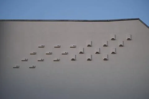 Bird Nesting Boxes Installed on Building Facade for Urban Wildlife Stock Photos