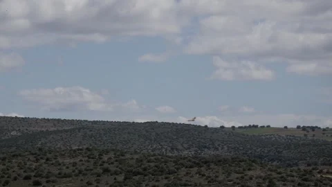 Bird Soaring High Above Rolling Hills and Cloudy Sky in Open Countryside Stock Footage 336577537