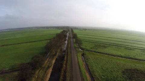 Bird view flying above an empty road between grasslands landscape 4k Stock Footage 57058945