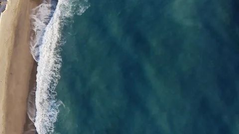 Bird view of ocean waves crashing into sandy beach Stock Footage 168902553