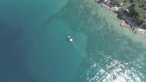 Bird view tracking shot slowly sailing boat thru a colorful textured seafloor. Stock Footage 146828561