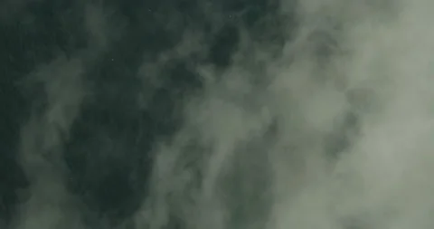 Bird's eye aerial shot flying through the clouds with ocean below Stock Footage