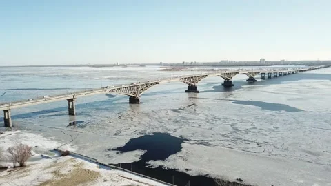 Bird's-eye bridge across the spring river and city Video stock 130404372