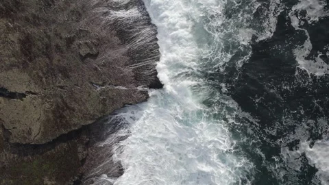 Birds Eye Drone View of Ocean Waves Breaking on Rocky Coast of Ireland Stock Footage 346900754