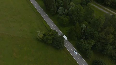 Birds eye perspective of a white camper van road tripping across France in Stock Footage 346339294