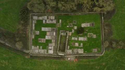 Bird's eye view above graveyard concrete plots and walls in lush green Stock Footage 263535892