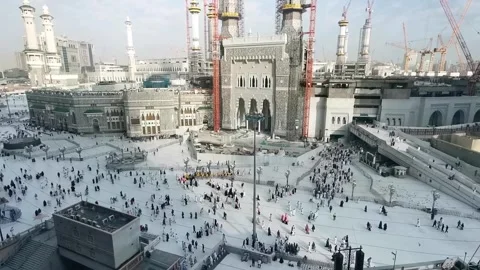 Bird's eye view and pan up shot of Muslim pilgrims outside Masjid Al Haram Stock Footage 274459532