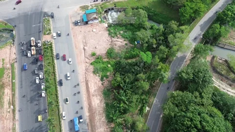 Bird's-Eye View of Bustling Roads Intersecting Verdant Expanse and Developing 스톡 동영상 320107292
