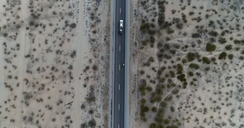 Birds eye view of car overtaking cyclist on straight road drone aerial 4K Stock Footage 111311151
